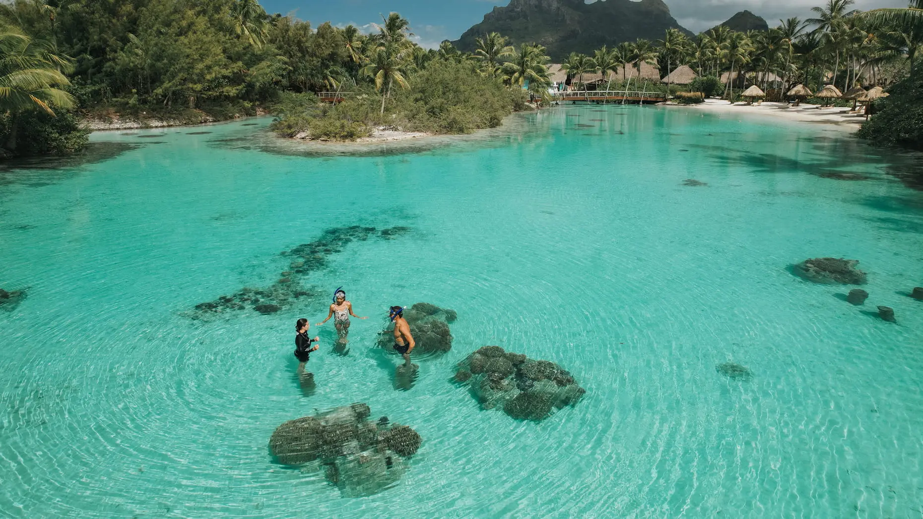 Familia haciendo snorkel en la laguna del Four Seasons Bora Bora
